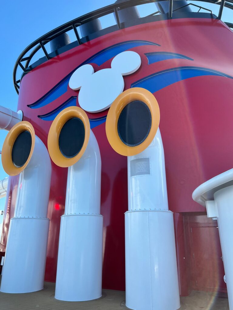Iconic red Disney Cruise Line funnel beneath a blue sky